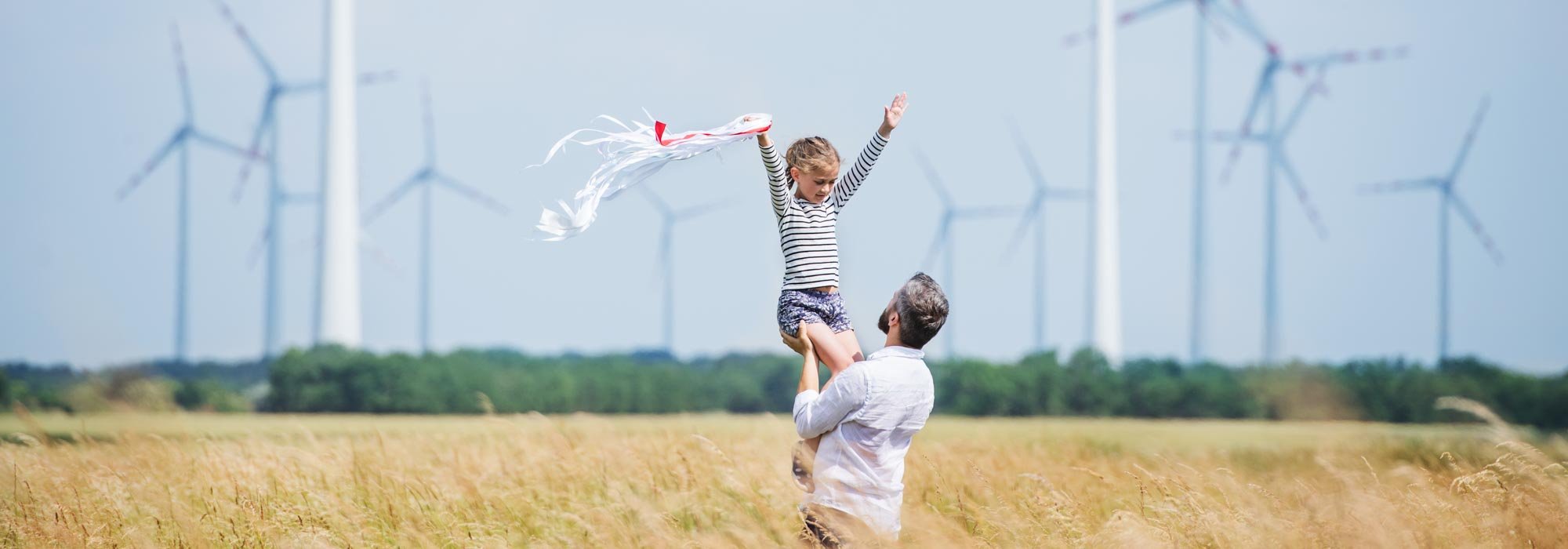 Fröhliche Kinder vor einem Windpark